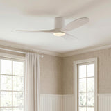 A transitional living room featuring the Eider LED Ceiling Fan with matte white oak blades along the ceiling above beige wallpaper and white wainscoting.