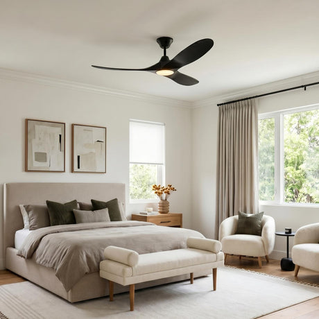A contemporary bedroom with a matte black Egret LED Ceiling Fan 52 inch centered over a neutral upholstered bed with white boucle accent chairs.