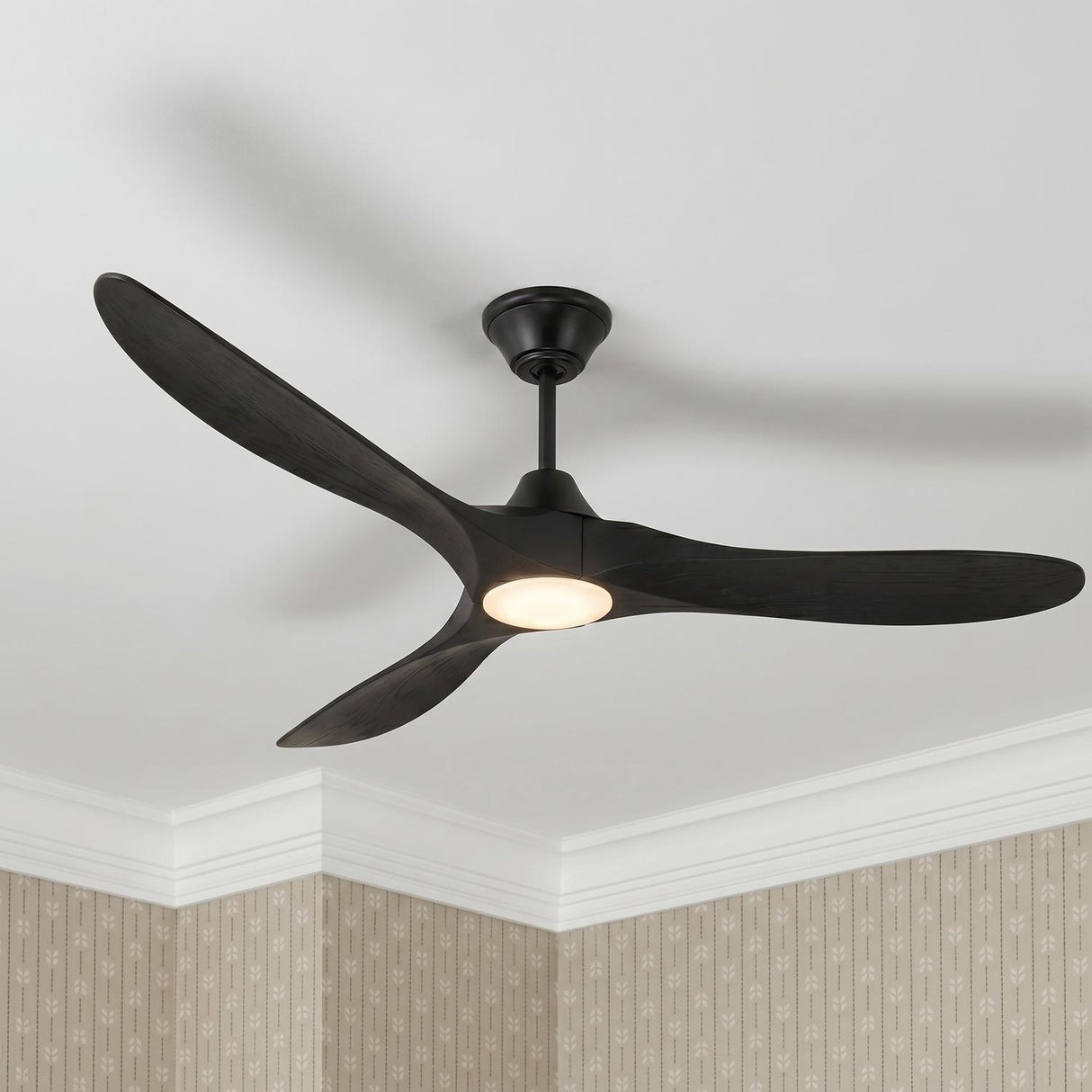 A transitional bedroom featuring the Egret LED Ceiling Fan 70" with matte black oak blades and a glowing frosted glass light against patterned taupe wallpaper.