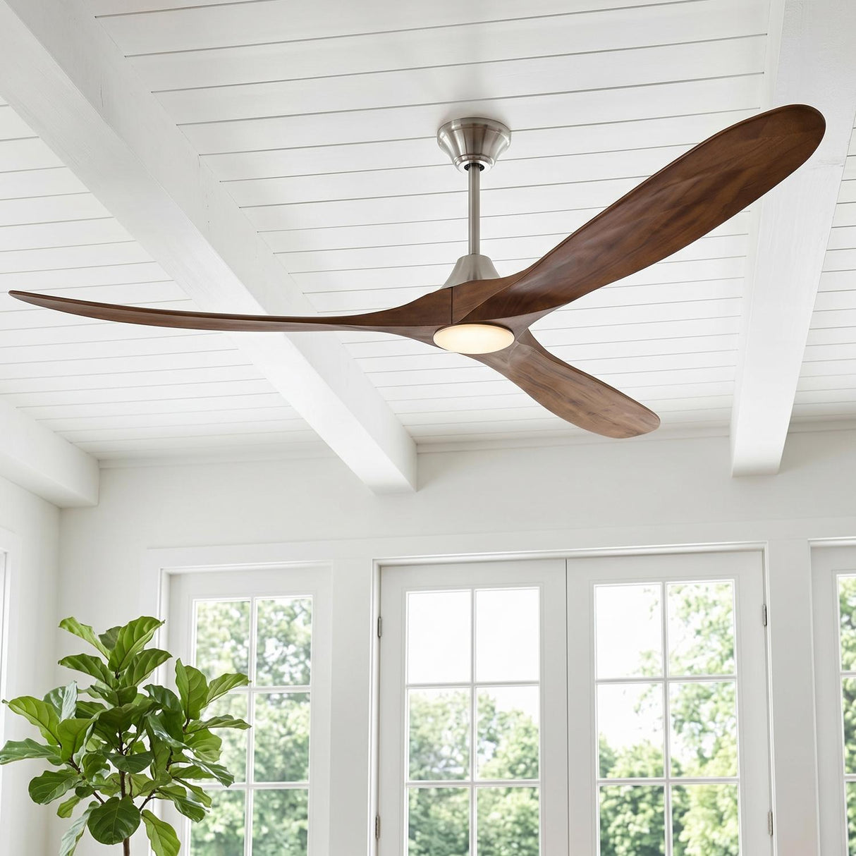 A modern farmhouse living room featuring the Egret LED Ceiling Fan 70", Walnut Wood and Brushed Steel, mounted on a white beamed shiplap ceiling near glass doors.