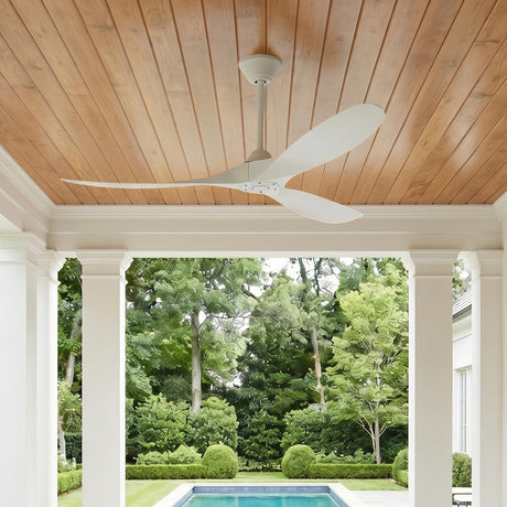 A modern farmhouse porch with a wood-plank ceiling featuring the Egret Outdoor Ceiling Fan 60" in matte white overlooking a swimming pool and manicured boxwood.