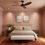 A contemporary bedroom with the Heron Smart Ceiling Fan 52", Walnut Wood and Matte Black on the ceiling center above a geometric headboard and pink grasscloth wallpaper.