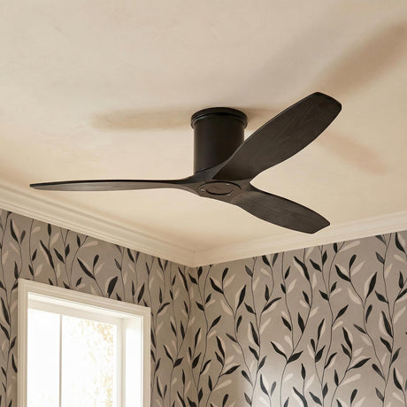 A transitional bedroom featuring a Harrier Smart Ceiling Fan 52", Matte Black Oak installed on a standard ceiling above gray floral wallpaper and a white window.