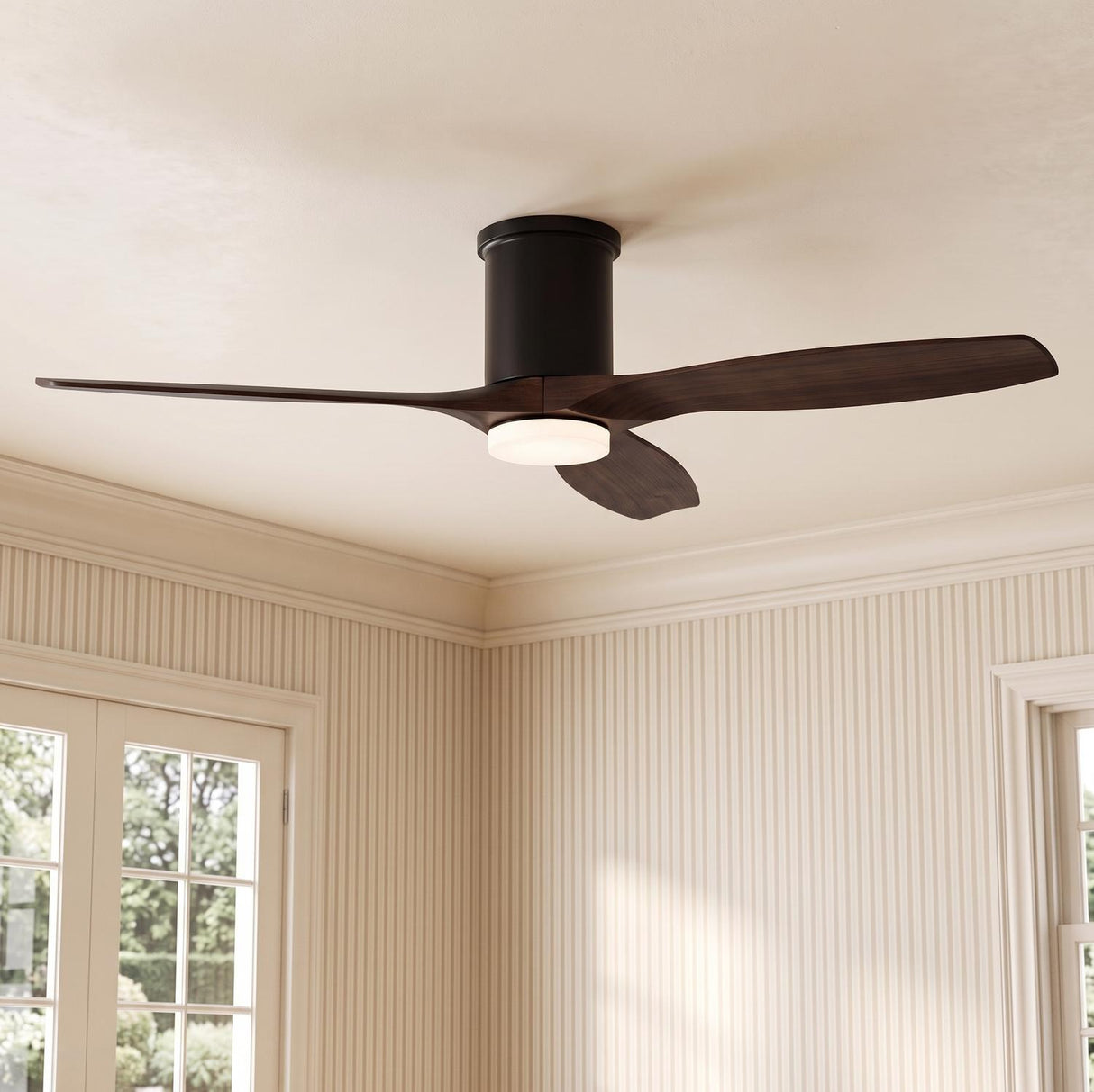 A transitional living room featuring a Harrier LED Smart Ceiling Fan 52" with walnut wood blades and matte black finish mounted above beige striped wallpaper and French doors.
