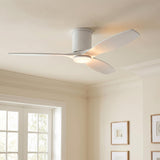 A contemporary living room with a matte white oak Harrier LED Smart Ceiling Fan 52" on the ceiling center near white French doors and framed wood art.