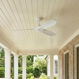 A traditional home porch with the Heron Outdoor Smart Ceiling Fan 60", Matte White on a shiplap ceiling beside a red brick wall, white columns, and boxwood hedges.