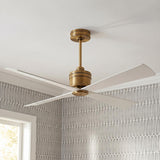 A modern bedroom with the Sora Ceiling Fan 56" in antique rubbed brass and matte white mounted to a ceiling with gray geometric patterned wallpaper.