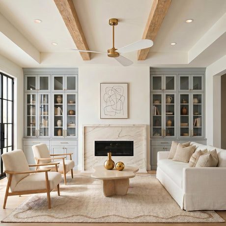 A transitional living room with the Willet Smart Ceiling Fan 60", Modern Brass and Matte White mounted to a beamed ceiling above a marble fireplace.