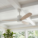 A modern farmhouse living room featuring a matte white and bleached oak Willet Smart Ceiling Fan 60" on a white beamed ceiling beside a fiddle leaf fig.