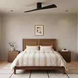 A modern bedroom with the Finch Smart Ceiling Fan 52 inch in matte black oak centered over a wood bed frame and nightstands.