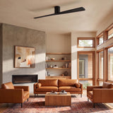 A modern living room featuring the Finch Smart Ceiling Fan 72-inch in matte black oak mounted above tan leather seating and a concrete fireplace.