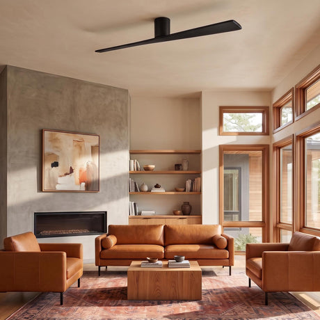 A modern living room featuring the Finch Smart Ceiling Fan 72-inch in matte black oak mounted above tan leather seating and a concrete fireplace.