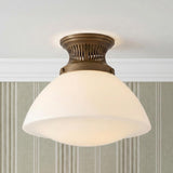 A traditional foyer with the Lennox Small Semi-Flush in vintage bronze and milk glass mounted to a white ceiling featuring striped wallpaper and crown molding.