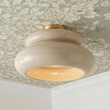 A traditional foyer with the Ellsworth Semi-Flush in taupe crackle ceramic and aged brass installed on a sage green floral wallpapered ceiling with crown molding.