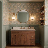 A transitional bathroom featuring the Fenton Wall Sconce in patina brass and seeded cloud glass flanking a round mirror over a walnut vanity.