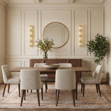 A transitional dining room with two aged brass and clear piastra glass wall sconces flanking a round mirror above a walnut sideboard and coffered ceiling.