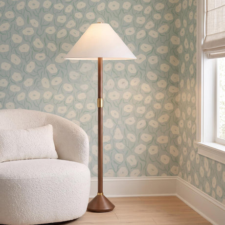A transitional living room featuring the Huegus Floor Lamp 65", Walnut and Aged Brass positioned next to a white boucle chair and floral patterned wallpaper.