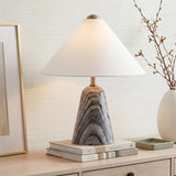 A transitional living room featuring a Hendrix Table Lamp 19 with a gray marble base and white linen shade atop a light wood console table.