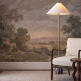 A transitional living room features the Hendrix Floor Lamp 64", Gray Marble and Patina Brass with a white cone shade beside a cream armchair and landscape mural.