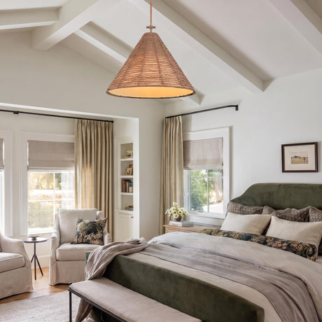 A modern farmhouse bedroom with a braided jute and patina brass cone pendant suspended from a vaulted beamed ceiling over a green velvet upholstered bed.