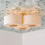 A transitional bedroom with the Wolfe Extra Large Semi-Flush in ivory boucle and aged brass on the ceiling center, featuring floral chinoiserie wallpaper and white crown molding.