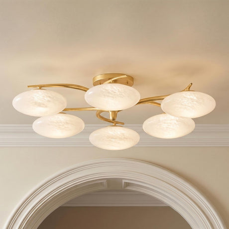A contemporary foyer featuring the Brinley 6 light LED semi-flush mount with gold leaf branches and cloud glass discs above a white arched doorway.