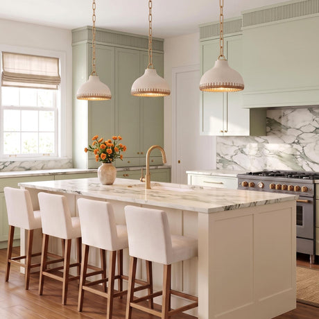 A modern farmhouse kitchen with three Nadira Small Pendants in cream, rattan, and aged brass over a white marble island with sage green cabinets and backsplash.