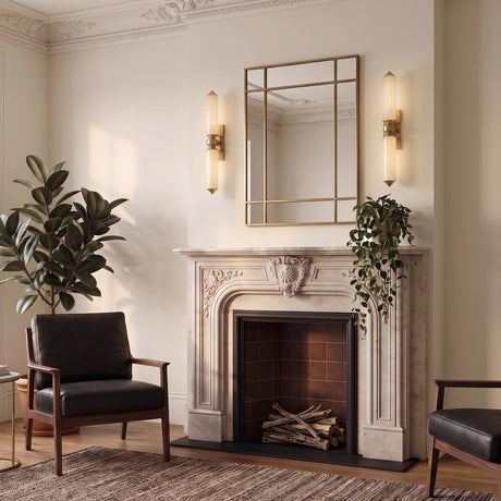 A transitional living room featuring the Prosper LED Wall Sconce in vintage brass and champagne seeded cloud glass flanking a mirror above a white marble fireplace.