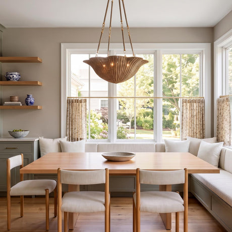 A coastal dining room with the natural jute Candela Large Chandelier 28" suspended over a light wood dining table and built-in banquette beside large windows.