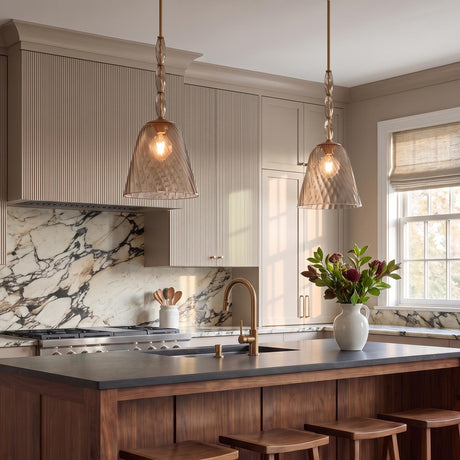 A transitional kitchen features two Bly Medium Pendants in aged brass and smoke taupe glass suspended over a rich wood island with a marble backsplash.