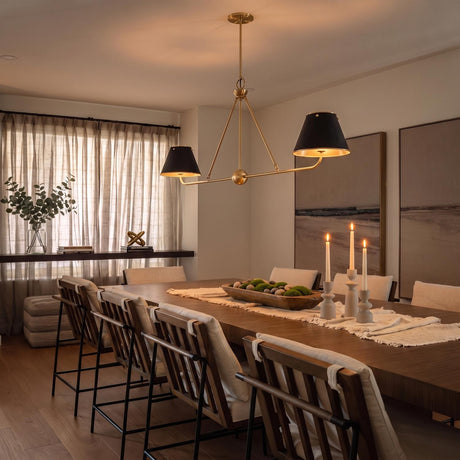 A transitional dining room with a Chesterfield 2 Shade Linear Pendant in aged brass and distressed bronze over a long walnut table with white upholstered chairs.