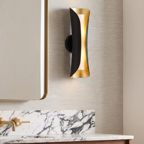 A contemporary bathroom featuring the Rhys Wall Sconce 21", Matte Black and Gold Leaf mounted beside a gold-framed mirror above a white marble vanity backsplash.