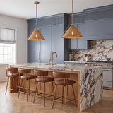 A transitional kitchen with two Gwenneth Medium Pendants in patina brass and rattan over a marble waterfall island with blue cabinetry and brown leather barstools.