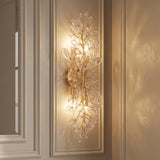 A transitional hallway with an Esme Wall Sconce 24", Soft Brass and Clear Glass featuring leaf accents mounted on a beige paneled wall.