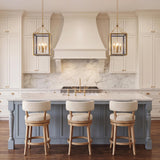 A transitional kitchen featuring two Ramona Medium Lantern Pendants in brushed brass and vintage blue over a marble island with a blue base and cream stools.