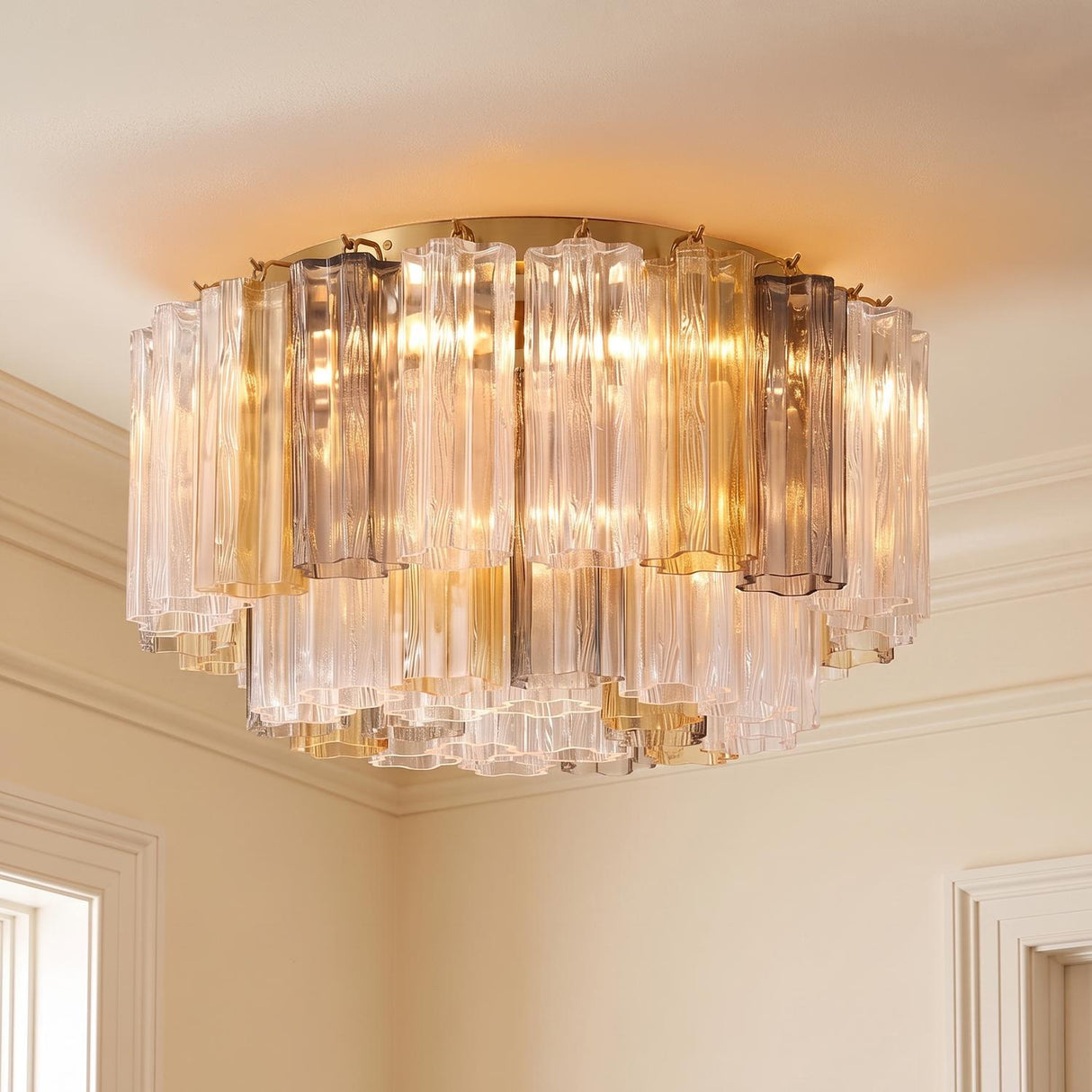A transitional foyer with the Grace Flush Mount 22 inch, Brass with Gilded Fog Glass installed on a standard ceiling with white crown molding and cream walls.
