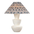 Andrea modern table lamp with a cream-colored stacked ceramic base and a pleated conical shade featuring a slate blue and beige botanical pattern, set against a plain white background.