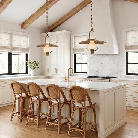 A modern farmhouse kitchen with two Leonel Medium Pendants in patina brass and seeded cloud glass over a white marble island under a vaulted beamed ceiling.
