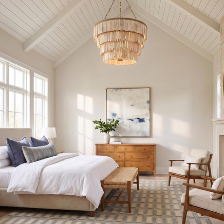 A modern farmhouse bedroom with the Hannigan Chandelier in whitewash wood and patina brass hanging from a vaulted beamed ceiling above a light wood dresser.