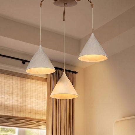A transitional bedroom with the Harlen 3 Light Chandelier, Patina Brass and Limewash suspended from the ceiling beside beige drapes and woven shades.