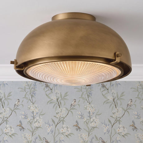 A transitional foyer with a patina brass flush mount featuring textured clear glass installed on a white ceiling above blue bird and floral wallpaper.