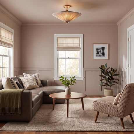A transitional living room featuring the Edric Semi-Flush in aged brass and natural linen on the ceiling above a leather sectional and a round walnut coffee table.