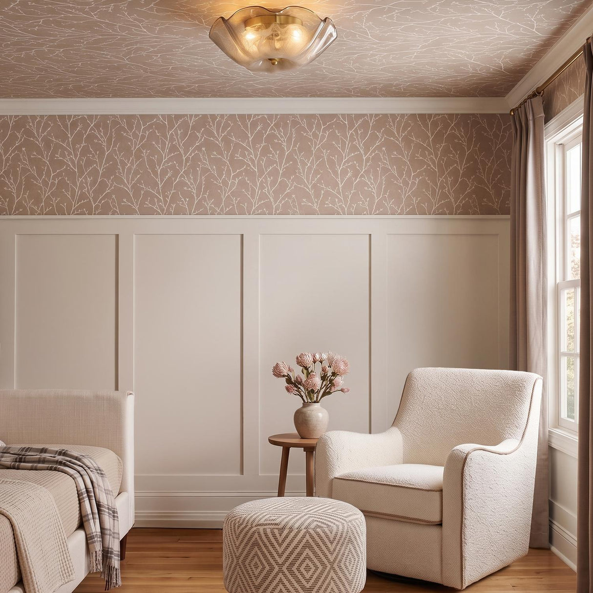 A transitional bedroom with the Fiorenzo Flush Mount in aged brass and smoke taupe glass along the ceiling above cream paneling and branch-patterned wallpaper.