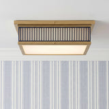 A transitional foyer with the Hawthorne Square LED Flush Mount in aged brass and midnight blue along the ceiling with blue pinstripe wallpaper and white crown molding.