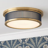 A transitional foyer with the Hawthorne Round LED Flush Mount 14", Aged Brass and Midnight Blue along the ceiling center with blue floral patterned wallpaper.