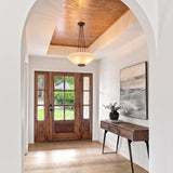 A transitional foyer with a distressed bronze and opal glass pendant hanging from a wood-paneled tray ceiling above a walnut console table and wood front door.