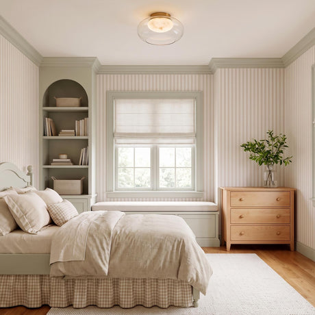 A transitional bedroom with the Nadia Small LED Semi-Flush 12" in aged brass and alabaster at the ceiling center near striped wallpaper and sage green shelving.