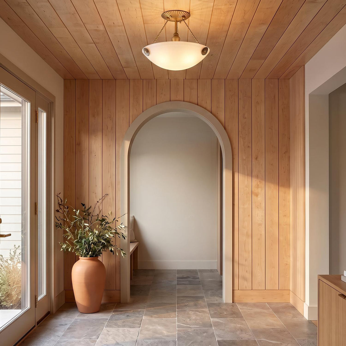 A contemporary foyer with the Azurae Semi-Flush 15 inch in patina brass and cloud glass on a wood paneled ceiling near a large terracotta floor vase.
