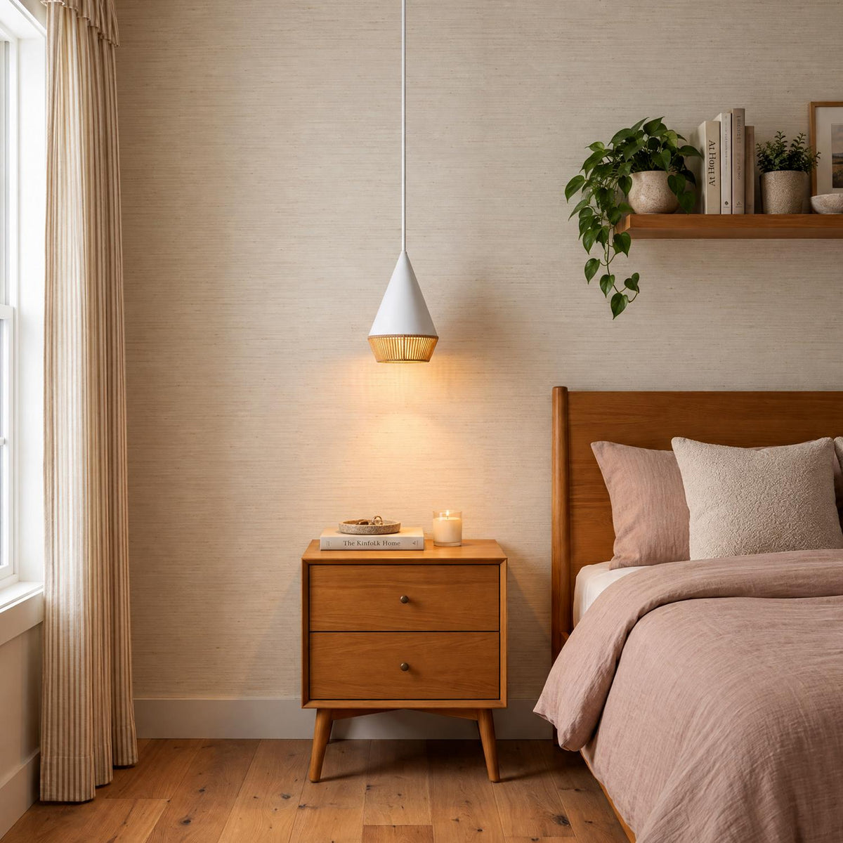 A mid-century bedroom with a Sunita Small Pendant 7", Matte White and Rope suspended above a wooden nightstand next to a matching bed.
