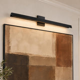 A contemporary living room featuring a matte black Avel LED Picture Light 37", Black mounted above a large framed abstract painting on a neutral wall.
